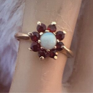 10k yellow Gold Ring with Garnet and White Opal Gemstones.
Size 7.5